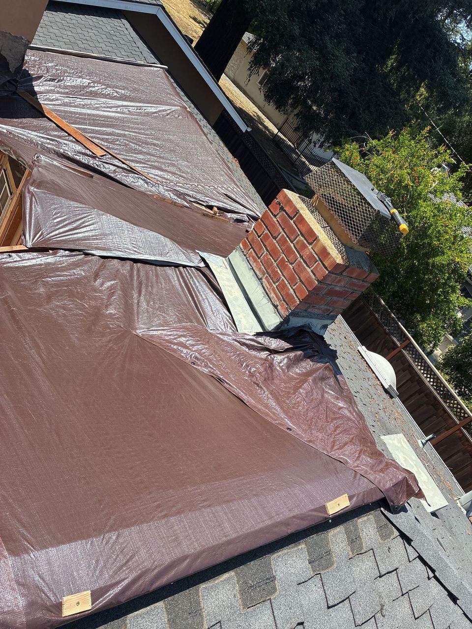 Tarped roof after emergency response — chimney detail