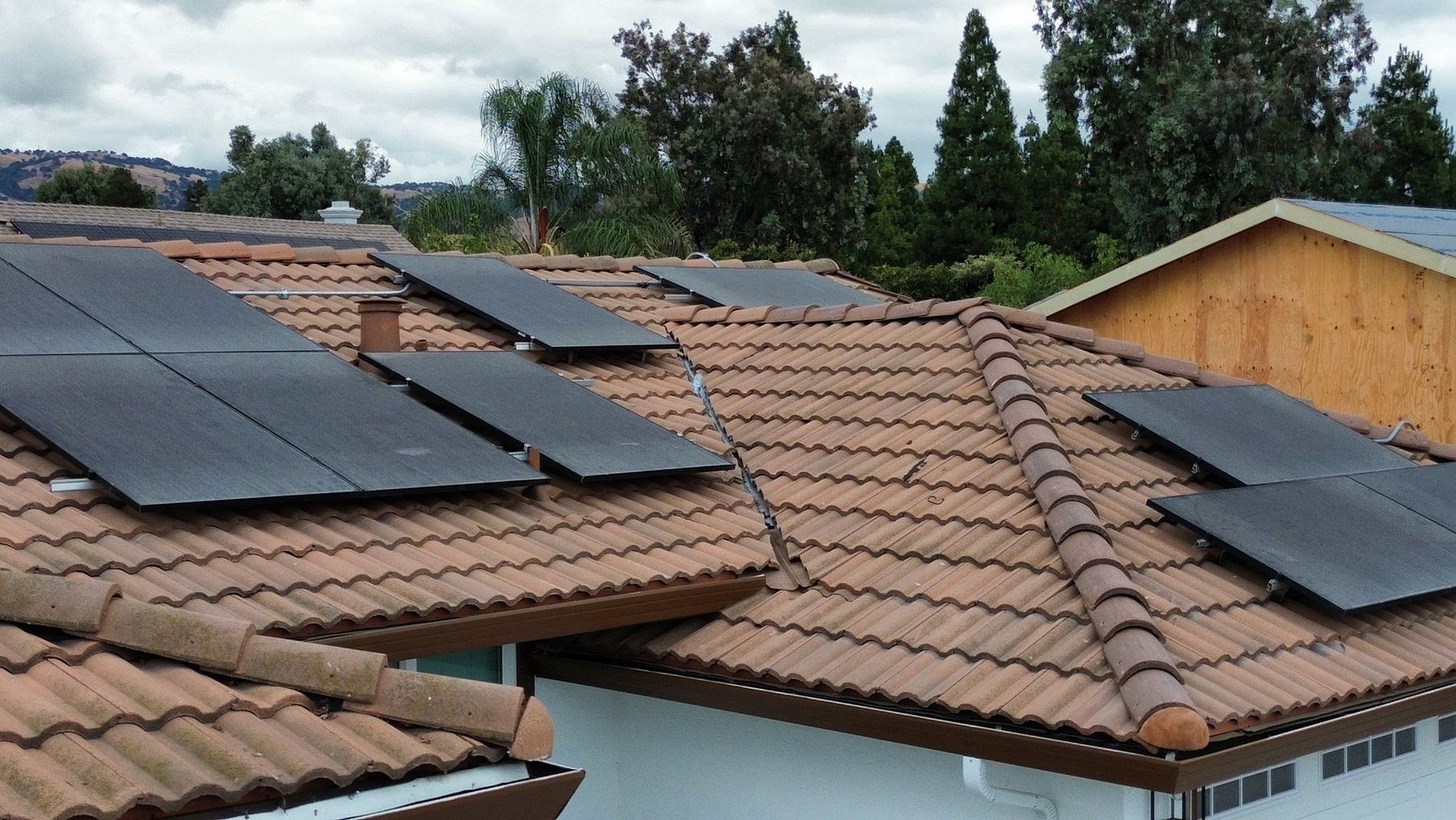 Concrete tile roof with solar panels — Evergreen fire repair drone view