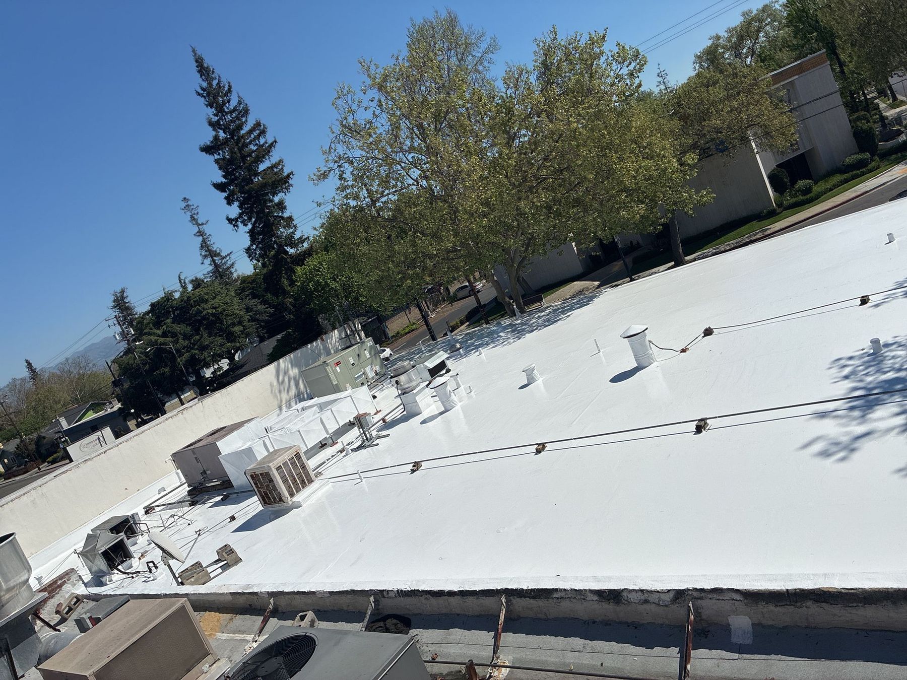 Freshly-applied white silicone roof coating on a commercial building in San Jose by Keith Roofing Company